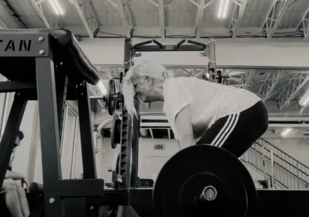 Older athlete performing a deadlift in a commercial gym
