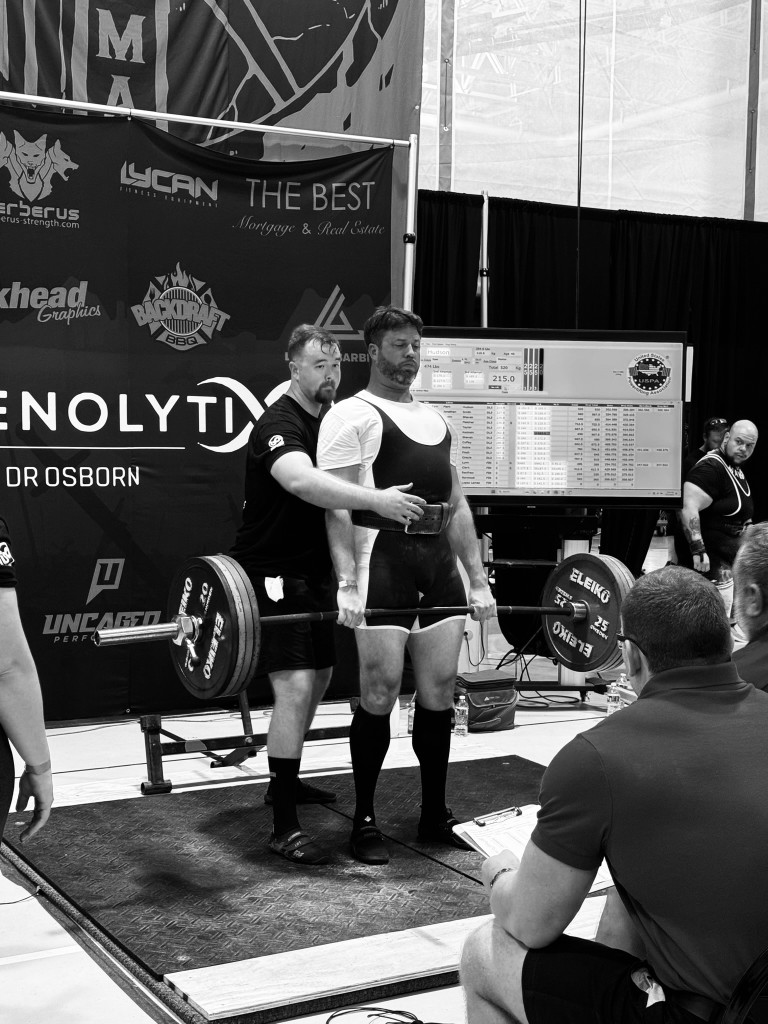 Athlete stepping onto lifting platform toward barbell