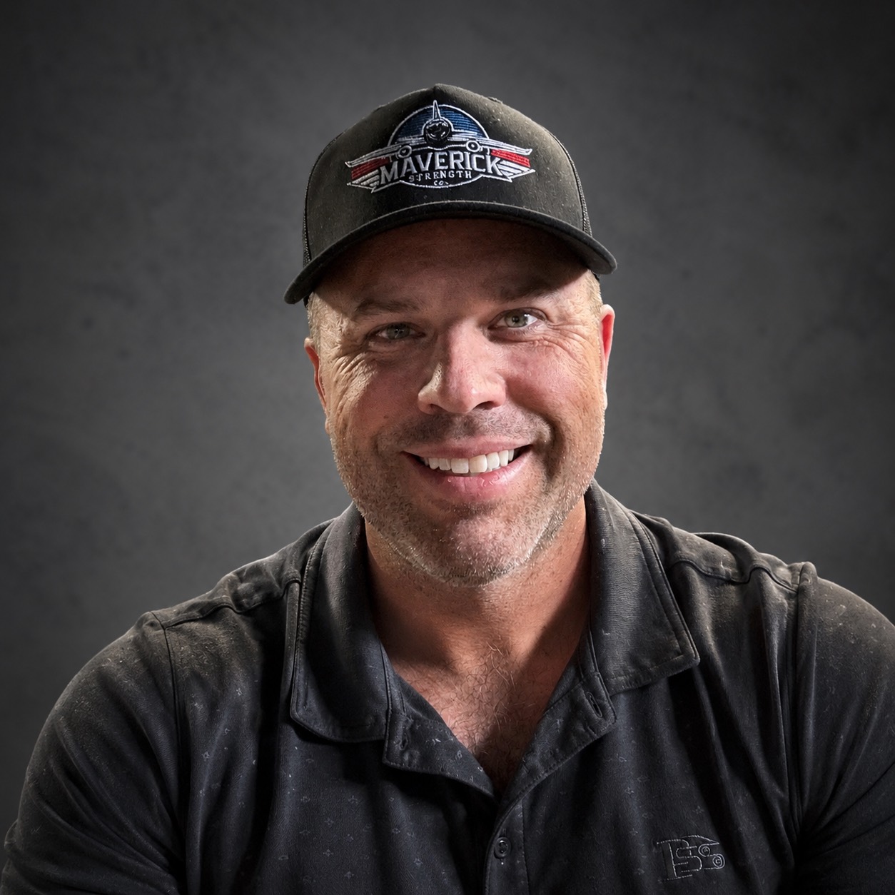 Coach Marc Hudson smiling in a Maverick Strength hat